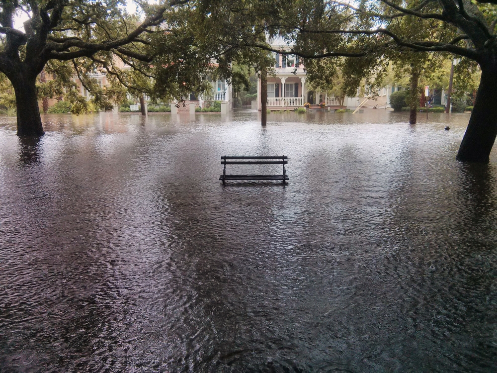 Park bench and historic homes flooded on a Charleston street